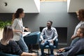 Smiling multiracial colleagues listening to skilled female team leader. Royalty Free Stock Photo