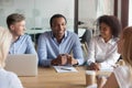 Smiling multiracial colleagues negotiate cooperating at meeting Royalty Free Stock Photo