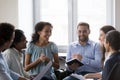 Smiling multiracial colleagues take part in motivational training at workplace