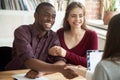 Smiling multiracial couple customers shaking hands with broker o