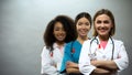 Smiling multiracial doctors with red ribbons, international AIDS awareness sign