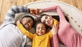 Smiling multiracial family lie on the floor