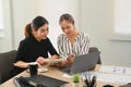 Smiling multiracial female colleagues using laptop and preparing presentation for company clients or investors Royalty Free Stock Photo