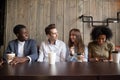 Smiling multiracial friends drinking coffee having fun in cafe Royalty Free Stock Photo