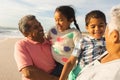 Smiling multiracial grandparents carrying grandchildren enjoying weekend together at sunny beach Royalty Free Stock Photo