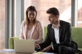 Smiling business colleagues negotiate at laptop in office Royalty Free Stock Photo
