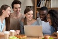 Smiling multiracial people using laptop together, having fun