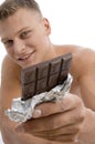 Smiling muscular guy showing chocolate