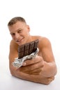 Smiling muscular man showing chocolate Royalty Free Stock Photo