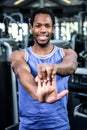 Smiling muscular man stretching arms