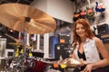 Smiling musician playing cymbals at music store