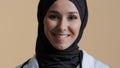 Smiling muslim arabian female doctor surgeon in hijab traditional headscarf wear medical coat looking front at camera Royalty Free Stock Photo