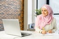 A young muslim woman wearing hijab using a laptop for studying Royalty Free Stock Photo