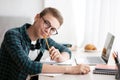 Smiling nerd guy enjoying his studying at home Royalty Free Stock Photo