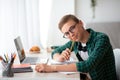 Smiling nerd guy enjoying his studying at home