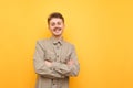 Smiling nerd in shirt and glasses stands on yellow background and poses at camera. Portrait of cheerful student with mustache and