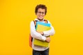 Nerdy boy with glasses holding books, orange backpack Royalty Free Stock Photo