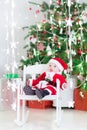 Smiling newborn baby boy in Santa costume under Christmas tree Royalty Free Stock Photo