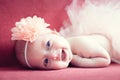 Smiling newborn baby girl with a flower in her hair Royalty Free Stock Photo