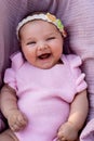 Smiling newborn baby girl with pink clothes and knitted head accessory Royalty Free Stock Photo