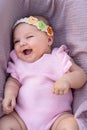 Smiling newborn baby girl with pink clothes and knitted head accessory Royalty Free Stock Photo