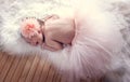 Smiling newborn girl with a flower in her hair Royalty Free Stock Photo