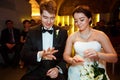 Smiling newlyweds look at their rings sitting in the restaurant Royalty Free Stock Photo