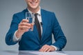 Smiling newsman holding a glass of water