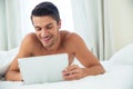 Smiling nude man using tablet computer Royalty Free Stock Photo