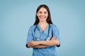 Smiling nurse with arms crossed, blue background Royalty Free Stock Photo