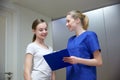 Smiling nurse with clipboard and girl at hospital Royalty Free Stock Photo