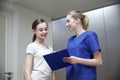 Smiling nurse with clipboard and girl at hospital Royalty Free Stock Photo