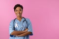 smiling nurse with crossed arms wearing pink ribbon Royalty Free Stock Photo