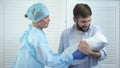 Smiling nurse giving young happy father newborn child, miracle of birth, care