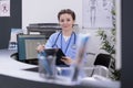 Smiling nurse holding clipboard checking medical report while working at patient medication treatment Royalty Free Stock Photo