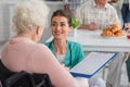 Smiling nurse holding clipboard near blurred Royalty Free Stock Photo