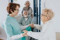 Nurse holds an elderly lady`s hands, helping her