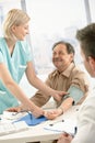 Smiling nurse measuring blood pressure of patient Royalty Free Stock Photo