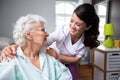 Smiling nurse and old woman patient at wheelchair