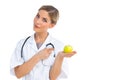Smiling nurse pointing to green apple on her hand Royalty Free Stock Photo