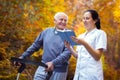 Smiling nurse reading book to senior man Royalty Free Stock Photo