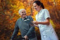 Smiling nurse reading book to senior man Royalty Free Stock Photo