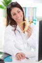 smiling nutritionist in office eating banana