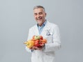 Smiling nutritionist holding fresh vegetables and fruit