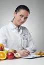 Smiling nutritionist writing medical records Royalty Free Stock Photo