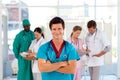 Smiling octor with his team in the background Royalty Free Stock Photo