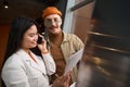 Smiling office manager standing beside her colleague during phone conversation Royalty Free Stock Photo