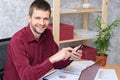 Smiling office worker corresponds on his smartphone Royalty Free Stock Photo