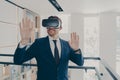 Smiling office worker in vr headset touching air and gesturing while working in virtual reality