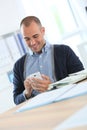 Smiling office worker taking a break with smartphone Royalty Free Stock Photo